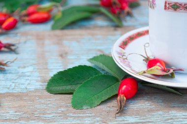 Geleneksel bir dogrose süsleme ile beyaz bir fincan çay. Eski bir ahşap arka plan kompozisyonu. Bitkisel çay. Ethnoscience. C vitamini
