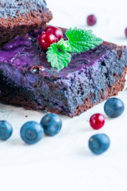 Yaban mersini ile hassas çikolatalı kek. Nane ve çilek bir delikanlı ile dekore edilmiştir. Beyaz arka plan üzerinde izole.