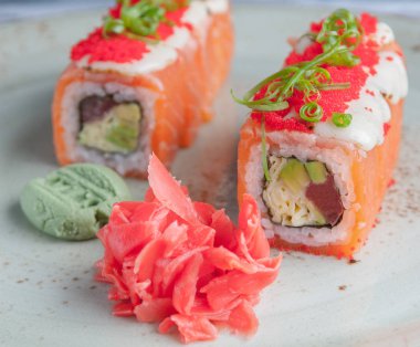 Shizu füzyon rulo. Somon, mozzarella peyniri ve masago ilavesi ile sarılı havyar. Avokado, Japon omlet ve tun doldurma