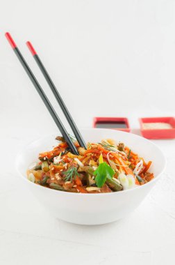 Erişte wok, sebze, otlar ve susam ile. 