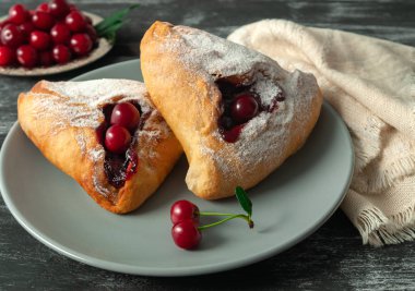 Kiraz ile üçgen ev yapımı kekler. Gri bir tabakta. Karanlık woo