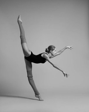 Siyah mayolu jimnastikçi ve bölmeleri yapan gaiters. Siyah beyaz fotoğraf