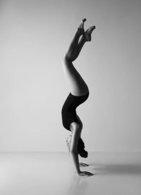 Siyah taytlı bir jimnastikçi. Siyah beyaz fotoğraf.