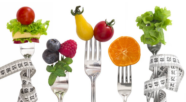 Diet Concept, vegetables and fruit on the forks isolated on white