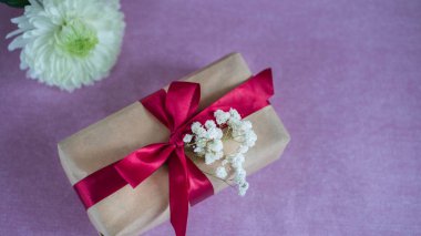 hediye kutusu beyaz çiçekler Gypsophila, Beyaz Krizantem dalı ile kırmızı kurdele ile bağlanmış bir pembe olduğunu