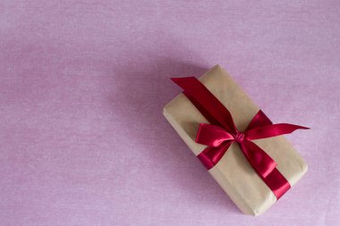 hediye kutusu alt köşesindeki Kraft kağıt sarılı ve kırmızı saten kurdele (yatay metin için yer ile bağlı olduğunu)