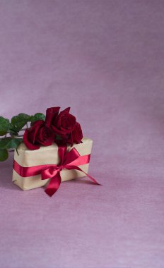 kutusu ile arka plan kırmızı kurdele ile üç kırmızı gül pembe arka plan (dikey, cope alanı üzerinde bağlı.)