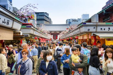 Tokyo Japonya - 28 Mart 2018: Nakamise alışveriş caddesi Sensoji Tapınağı'nda turistler alışveriş tatlılar ve Hatıra Eşyası hürmet heykel tapınak için gitmeden önce yürüyün. Tokyo'nun görülmesi gereken yerleri ziyaret etmek.