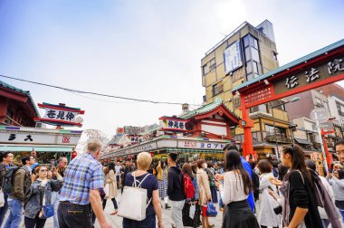 Tokyo Japonya - 28 Mart 2018: Nakamise alışveriş caddesi Sensoji Tapınağı'nda turistler alışveriş tatlılar ve Hatıra Eşyası hürmet heykel tapınak için gitmeden önce yürüyün. Tokyo'nun görülmesi gereken yerleri ziyaret etmek.