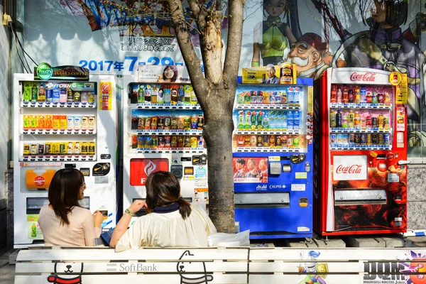 Tokyo Japonya - 4 Nisan 2018: Akihabara mahalle, kimliği belirsiz Japon kadın oturuyor ve otomat önünde konuşuyor. En popüler ve popüler Japon sermaye biridir.