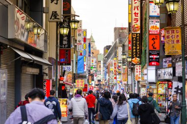Tokyo Japonya - 1 Nisan 2018: Shinjuku Mahallesi, kimliği belirsiz genç turist bu alan pek çok dükkan tam alışveriş ve restoran vardır geçmiş yürümek. Tokyo'nun görülmesi gereken biri gidilecek yerler.