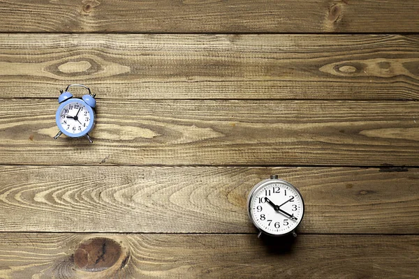 two alarm clocks  on wooden background