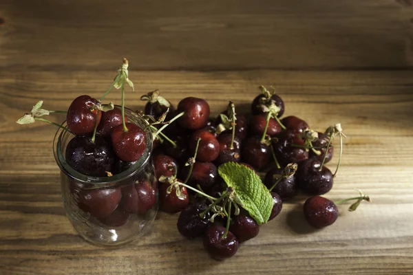 cherries on crystal bowl with water drops on wood table