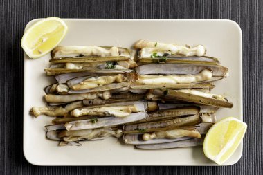 sarımsak, maydanoz, zeytinyağı ve limon dilim ahşap masa üzerinde jilet istiridye yemek ızgara