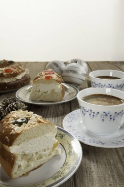 İki ağaç ve beyaz arka plan üzerinde İsa'nın doğuşu yakın çekim İspanyol tipik tatlı ve iki bardak kahve, çam kozalağı ve üç Noel topları parçalar koparıp