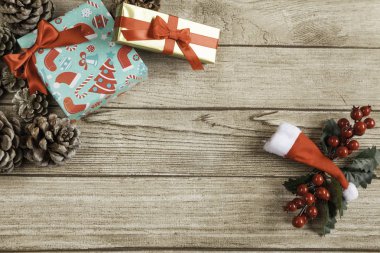 İki şampanya bardağı, Noel ağacı Noel topları, ökse otu ve hediyeler ve Noel çorap, Santas şapka ve ahşap arka plan üzerinde hediyeler ile dekore edilmiş