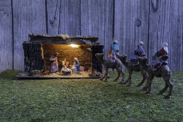 圣诞经理场景被耶稣 约瑟夫 牛和骡子和三个智者在草和木头背景照亮 — 图库照片