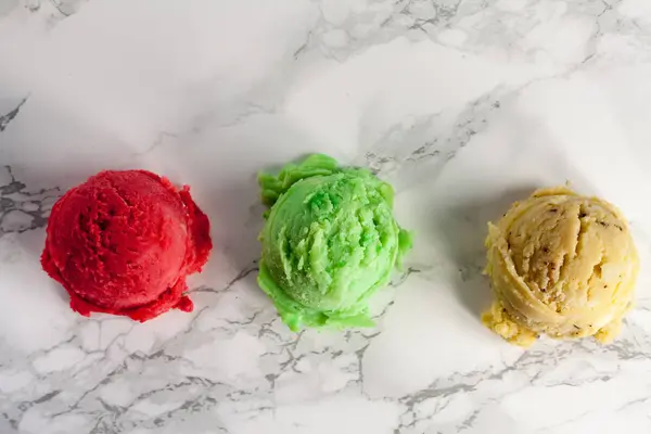 Three ice cream balls on marble from above — Stock Photo, Image