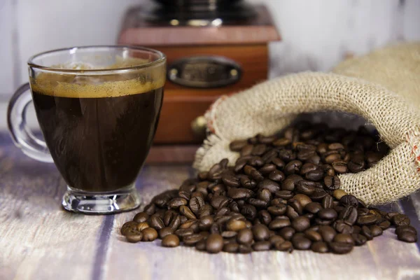 Cup of coffee and coffee beans coming out — Stock Photo, Image