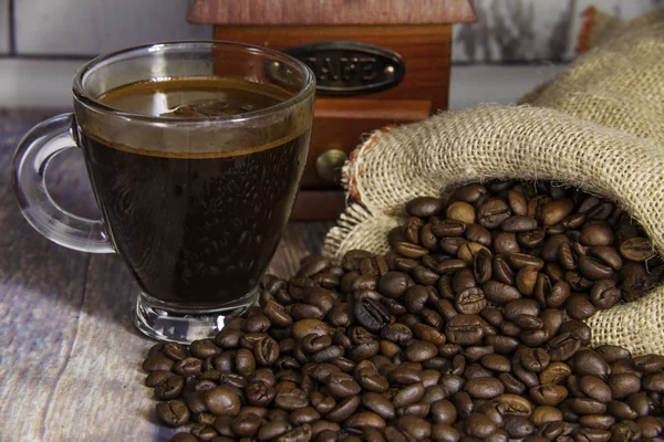 Delicious cup of coffee and coffee beans — Stock Photo, Image