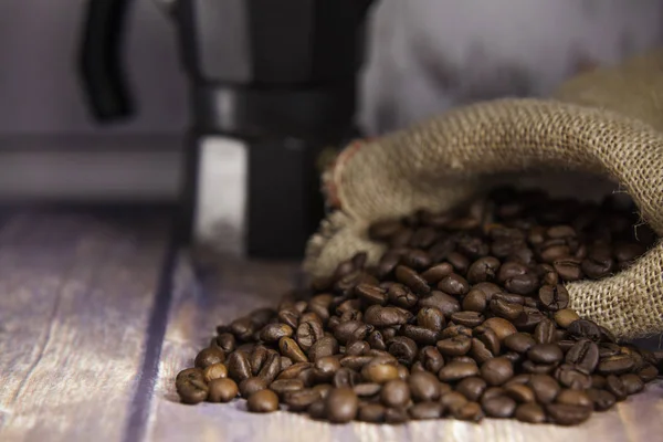 Coffee beans coming out of a sack  and coffee maker — Stock Photo, Image