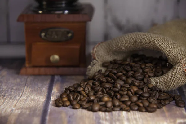 Coffee beans coming out of a sack and grinder coffee — Stock Photo, Image