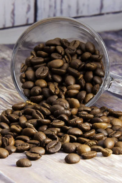 Coffee beans coming out of a glass cup — Stock Photo, Image