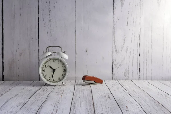 Relógio de alarme vintage branco e grampeador vermelho — Fotografia de Stock