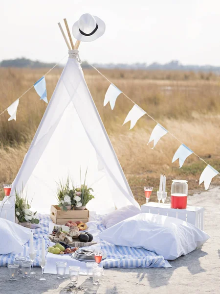 Pillows and food near cute tent.