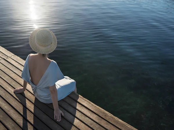 Elegant woman sitting near sea. — Stock Photo, Image