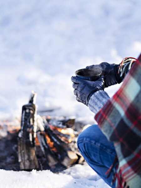 Crop man having warming drink outdoors.