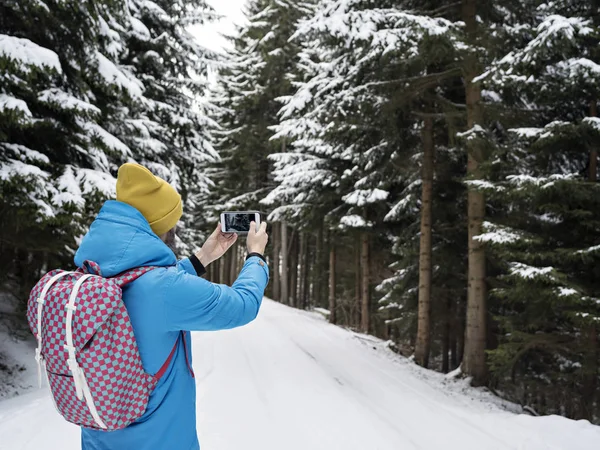 Homem tirando fotos de bosques nevados . — Fotografia de Stock