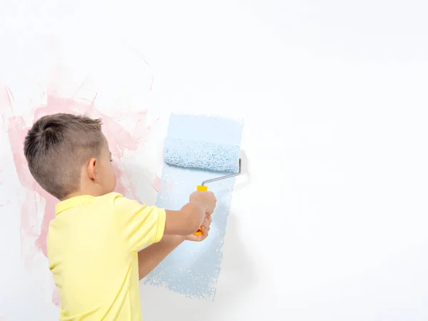 Kid painting the wall.