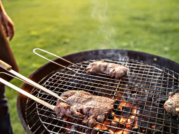 Scène d'un homme grillant de la viande en plein air. — Photo