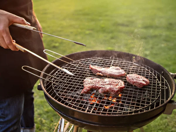 Scena człowieka grillującego mięso na świeżym powietrzu. — Zdjęcie stockowe