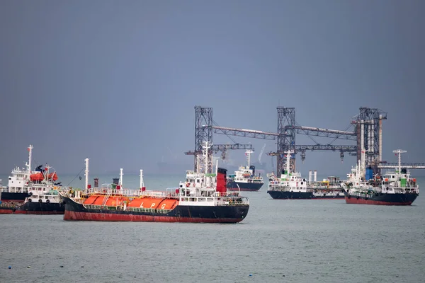 oil tanker, gas tanker in the high sea.Refinery Industry cargo ship. Import export LPG, Logistics and transportation with working crane bridge in harbor.