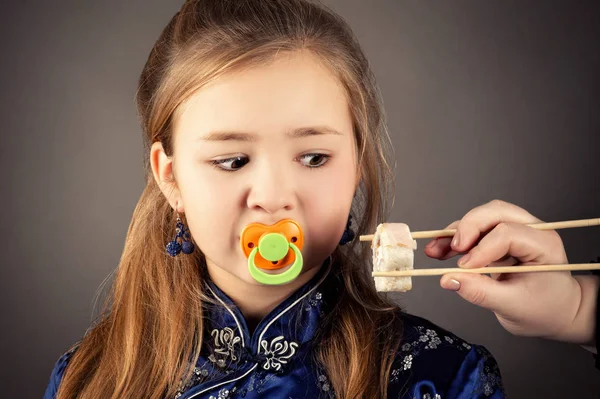 Attrayant Jeune Fille Avec Sucette Dans Bouche Regarder Sushi Rouleaux — Photo