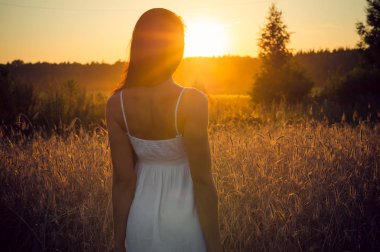 Yaz aylarında gün batımında geriye duran genç kadın
