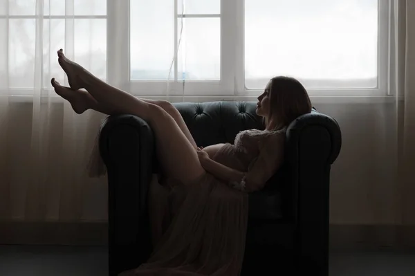 若い妊娠中の女性は奇跡を待っているソファに横たわっている — ストック写真