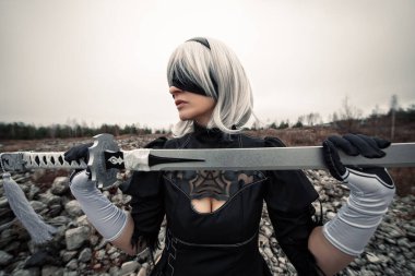 Beyaz peruklu ve gözleri bağlı bir kadın.