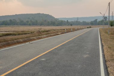 yol boyunca güneşli gün batımında dağ üstünde tepe.