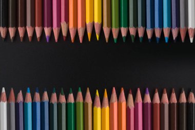 siyah arka plan üzerinde renkli kalemler yakın çekim