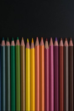 siyah arka plan üzerinde renkli kalemler yakın çekim