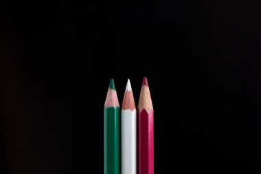 siyah arka plan üzerinde renkli kalemler yakın çekim.