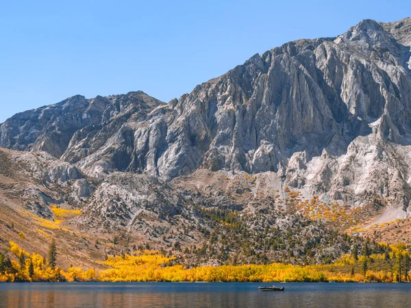 Tranquilla scena autunnale con una barca da pesca su un lago di montagna — Foto Stock