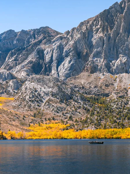 Tranquil autumn scene with a fishing boat on the lake — Stock Photo, Image