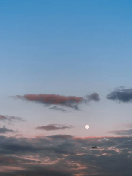 Aeronaves de corpo largo passam pela lua cheia ao pôr do sol Fotografia De Stock