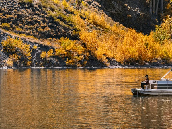 Impressionante paisagem de outono com pescador em um lago de montanha Imagens Royalty-Free