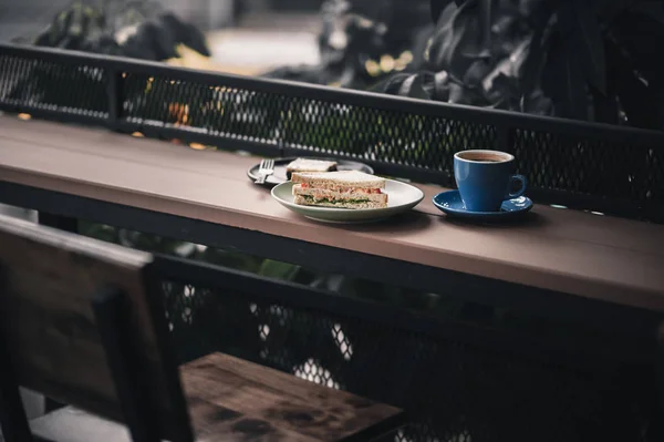 Sandwich a horká káva na dřevěný bar — Stock fotografie