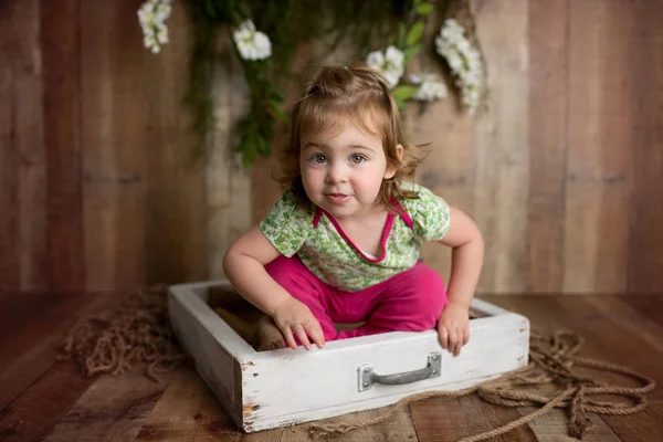 Cute little girl on brown wood background